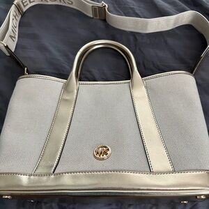 In great used condition! Micheal Kors bag! Has gold accents and tan canvas!